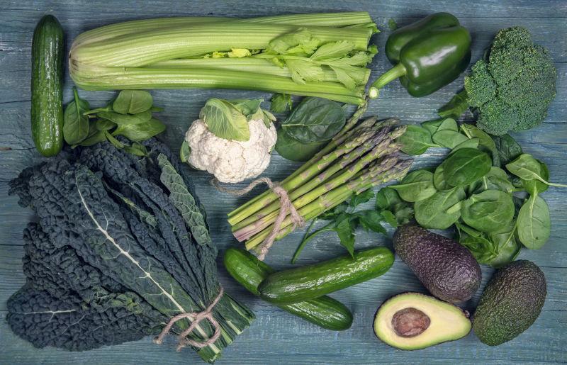 浅蓝色桌上的一些绿色的蔬菜