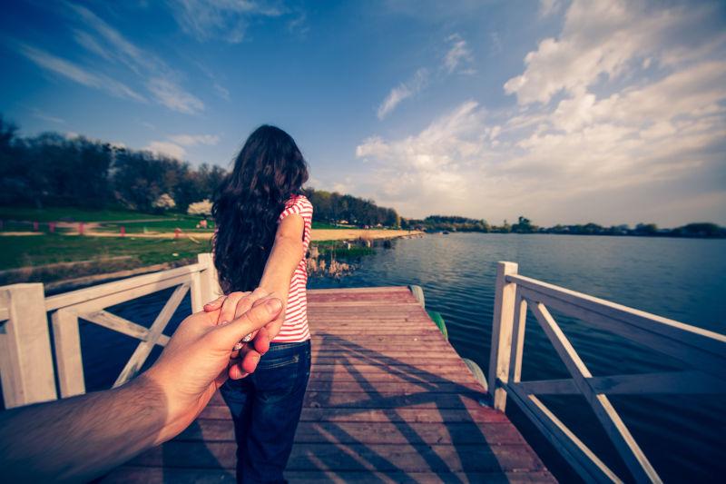 看海景的女孩牵着恋人的手