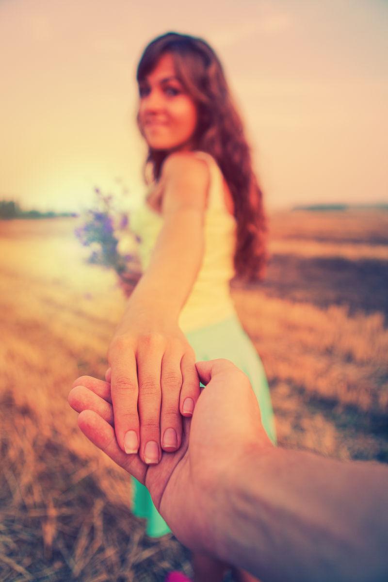 田野里女孩开心地牵着男友的手