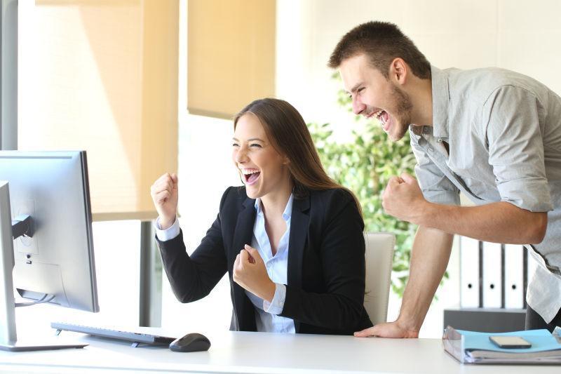 看台式电脑的兴奋的情侣