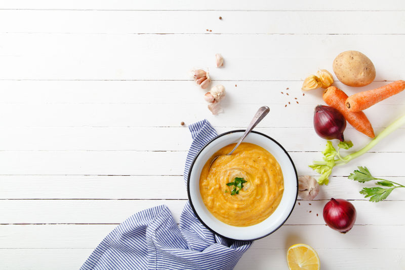 白色木板上的蔬菜和碗里的美食