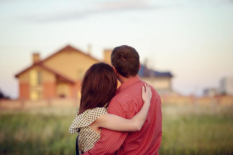 相爱的夫妇看着他们的家