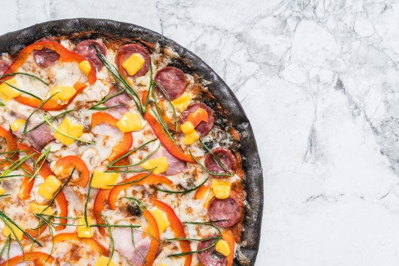 加满火腿和蔬菜的披萨饼