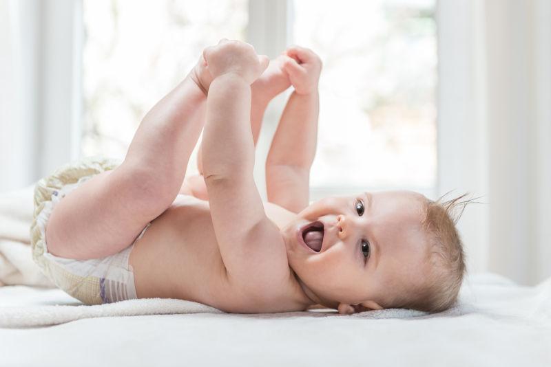 躺在床上张着嘴大笑的可爱的小宝吧