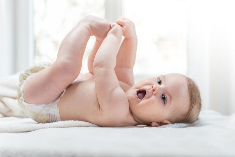 躺在洁白的床上长着嘴巴的可爱的小宝宝