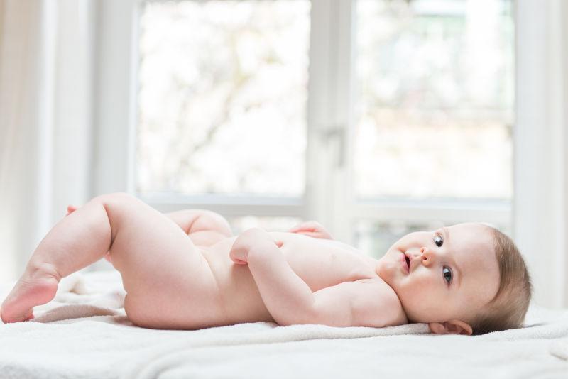 躺在床上没穿衣服的小婴儿