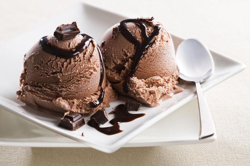 白色盘子里的加糖浆的巧克力冰淇淋