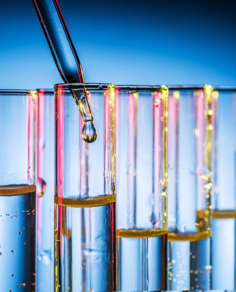 浅蓝色背景下使用滴管向试管中滴入液体