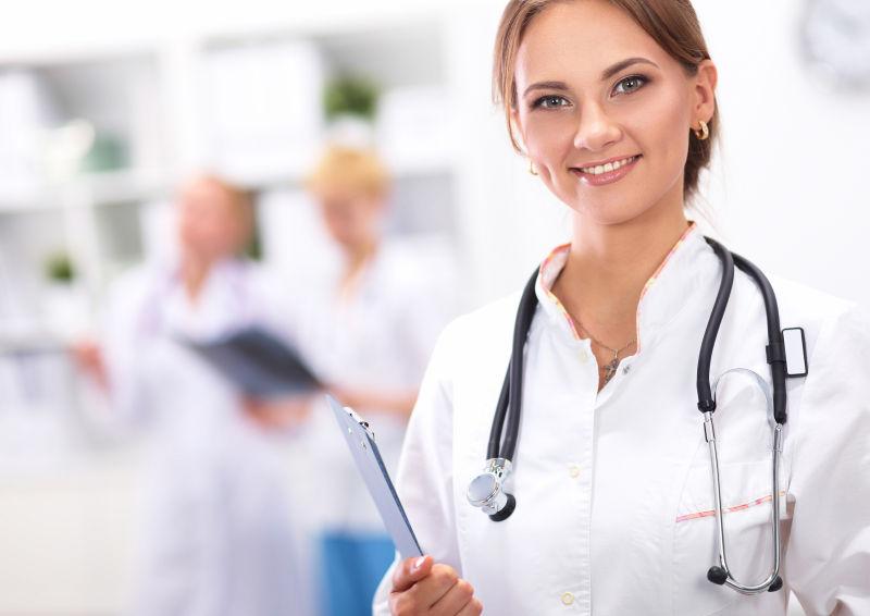 拿着文件夹戴着听诊器微笑的女医生