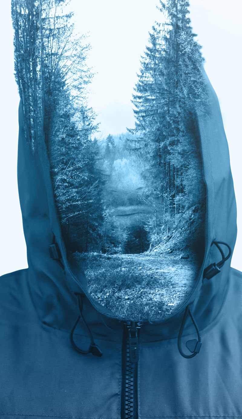 带帽子的人和森林的双重曝光