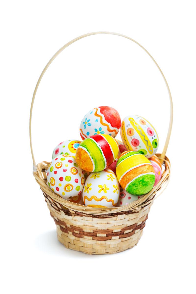 白色背景上的竹篮里的复活节彩蛋