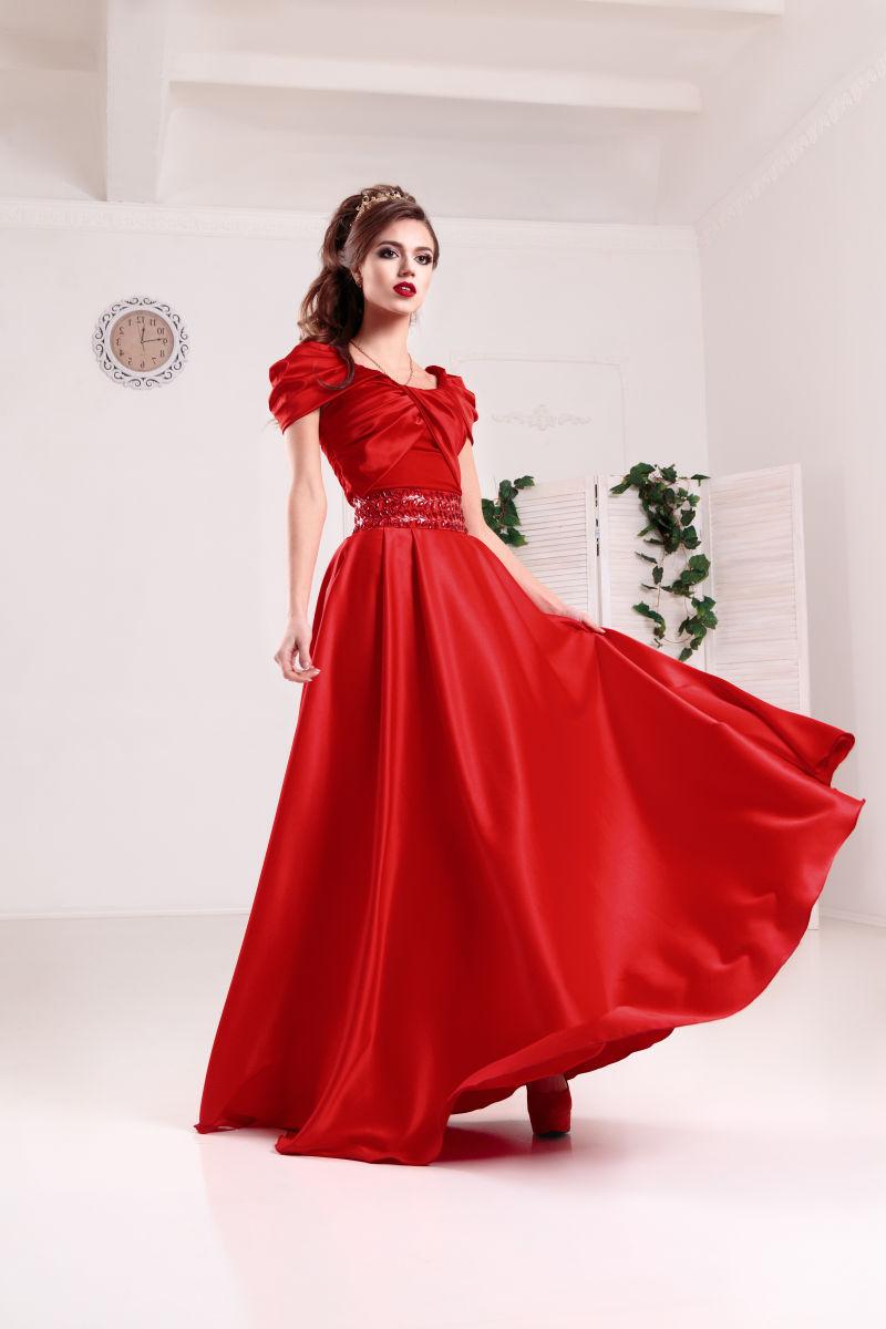 豪华房间内穿红礼服的优雅女人