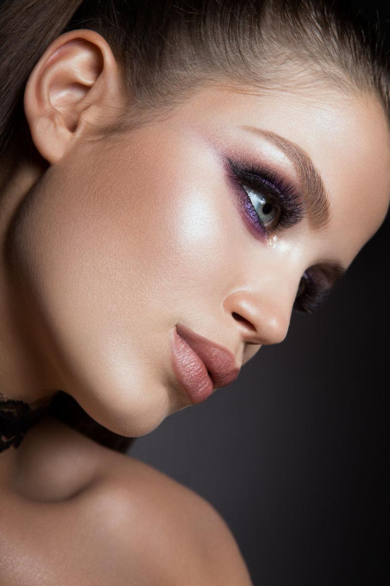 黑色背景上画着精致妆容的美女侧脸