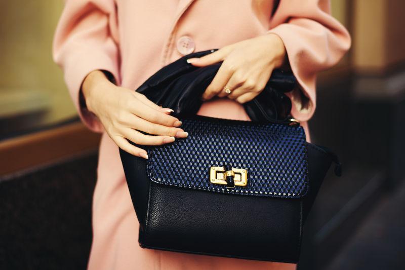 优雅的服装女性手拿黑色手袋