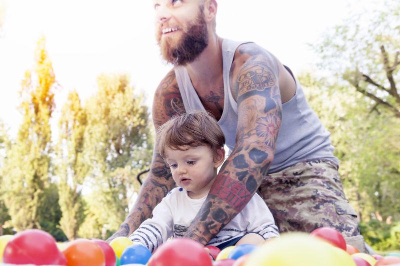 纹身父亲和儿子玩彩色球