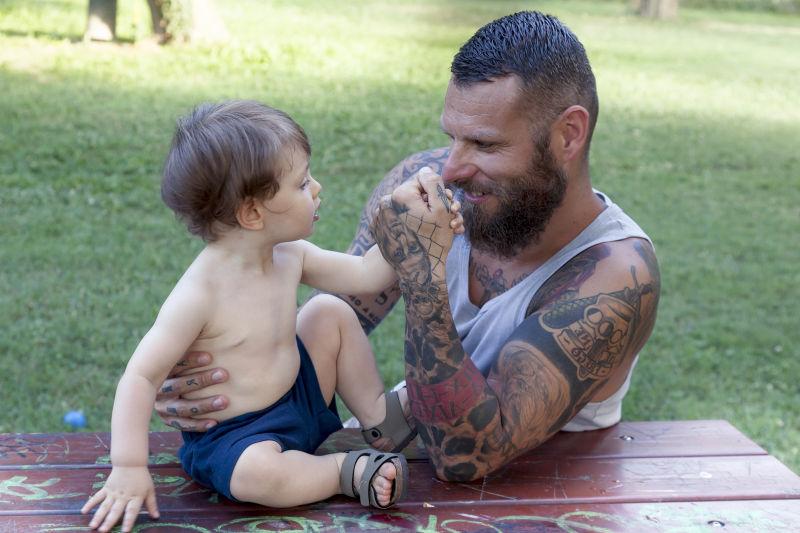 纹身父亲和儿子玩耍