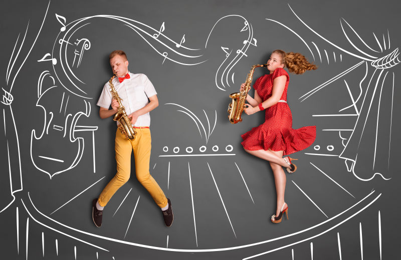 粉笔画背景中的一对浪漫情侣演奏萨克斯管的小夜曲