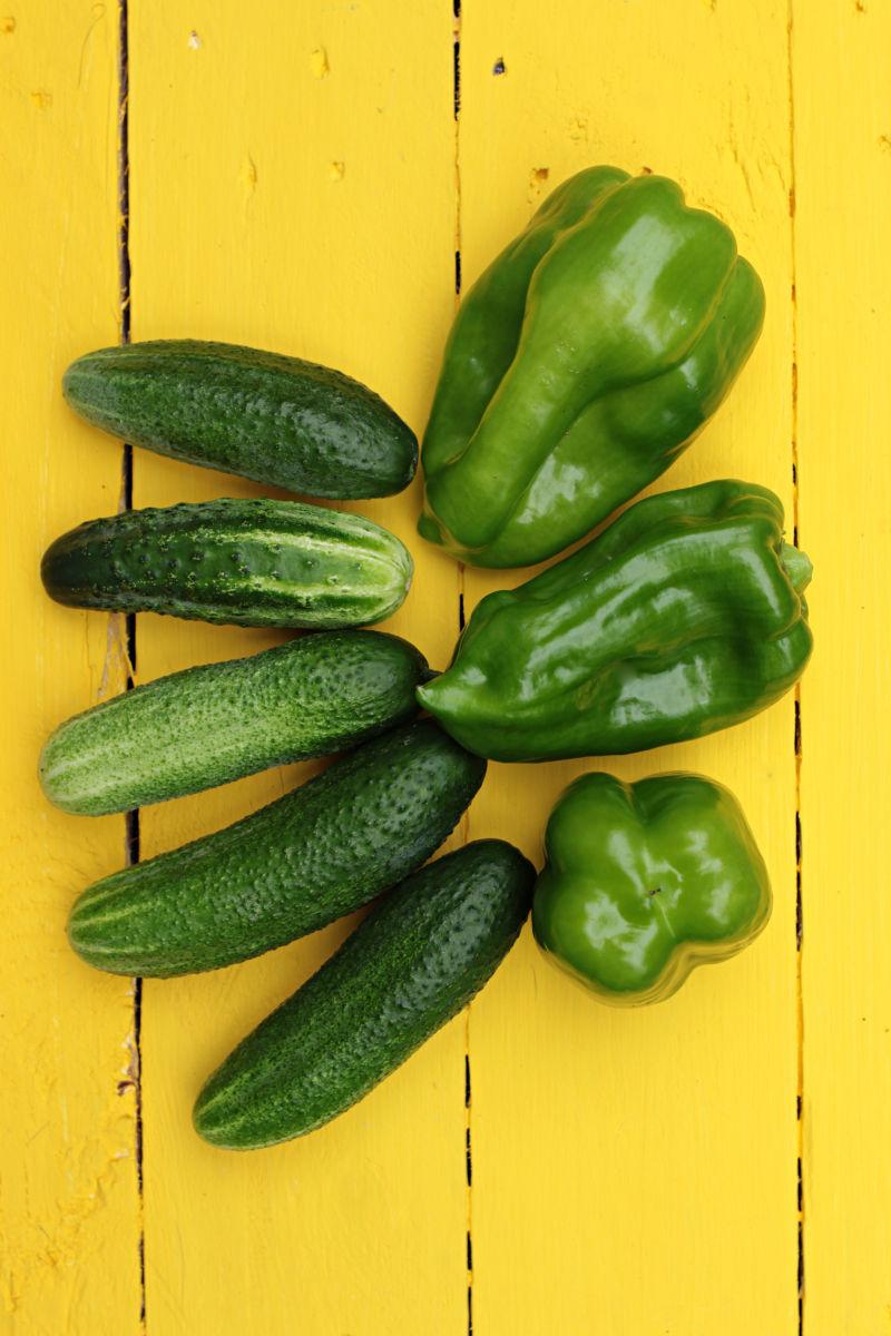 黄色背景下的黄瓜和青椒