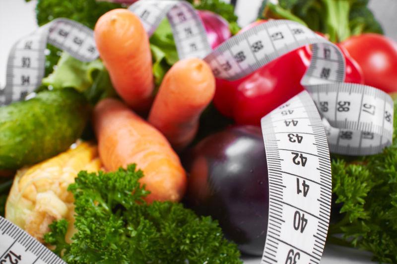 桌子上的新鲜健康蔬菜和皮尺