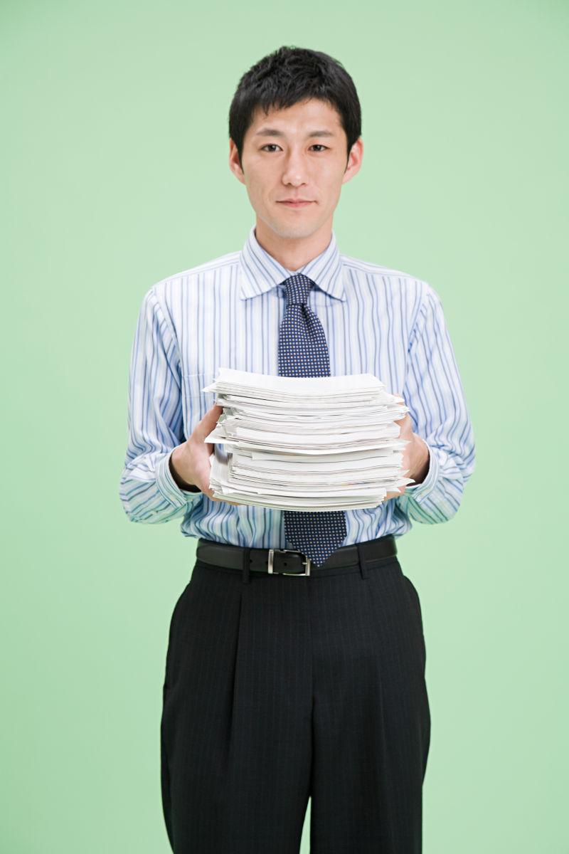 办公室工作人员拿着一摞纸