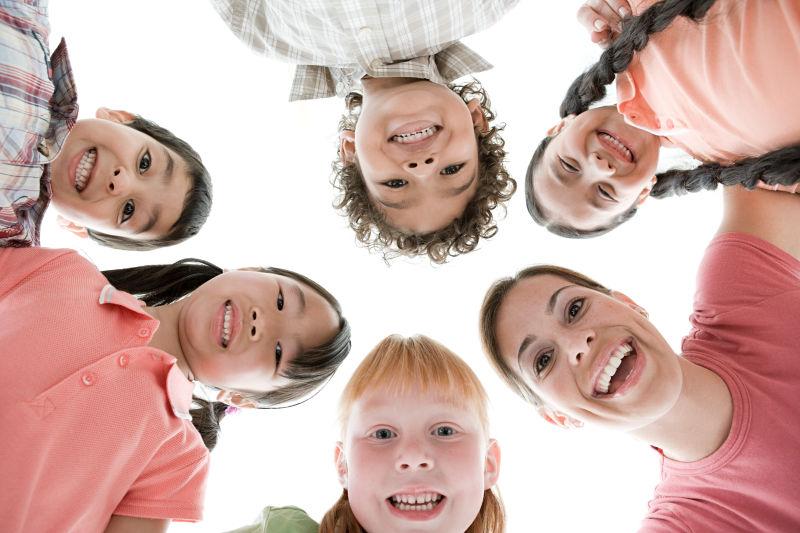 白色背景下低头微笑的老师和学生