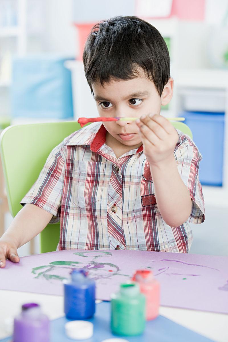 坐在桌子前画画的男孩