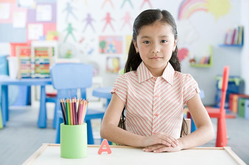 坐在教室内的课桌前的女学生肖像