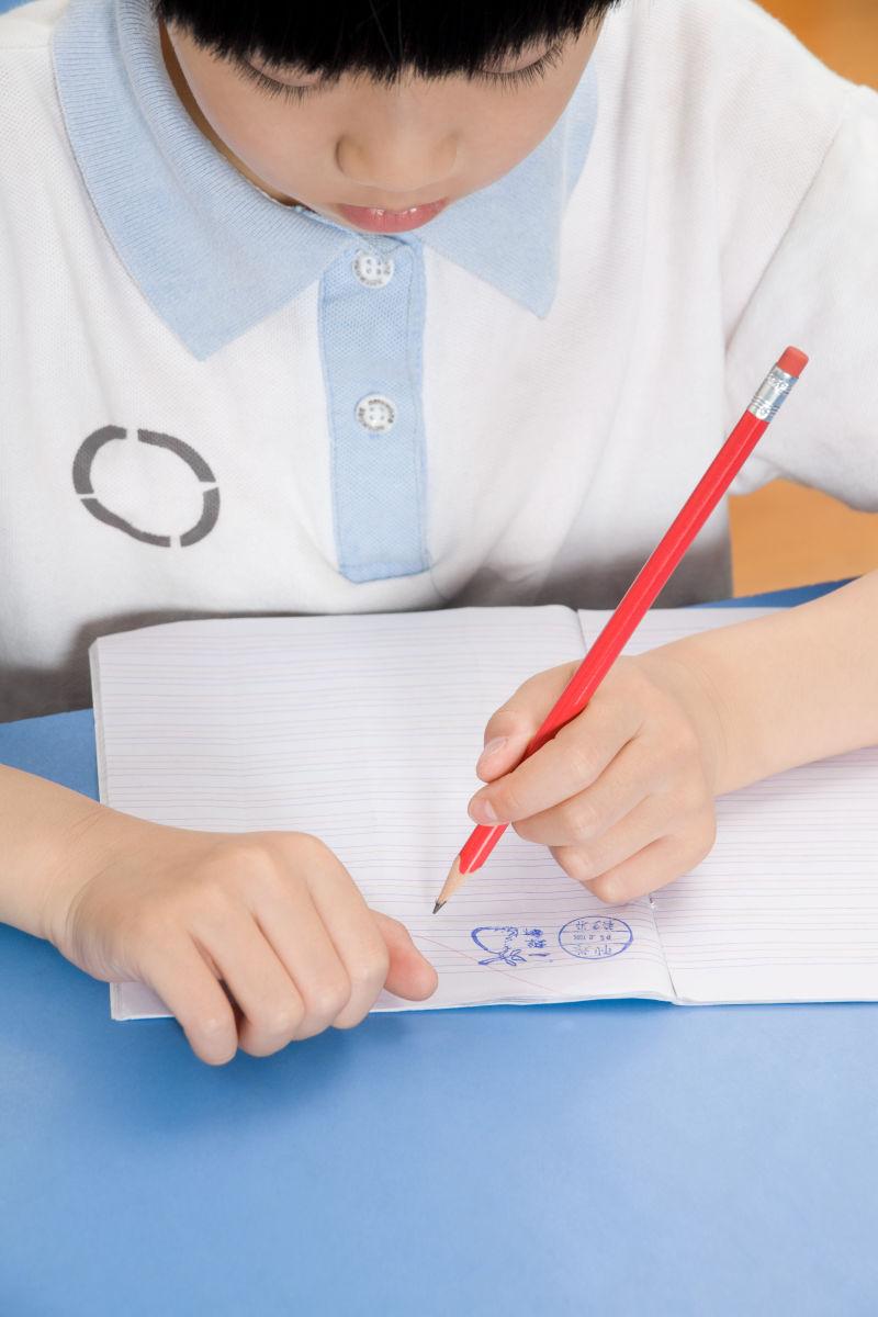坐在课桌前写字的小学生