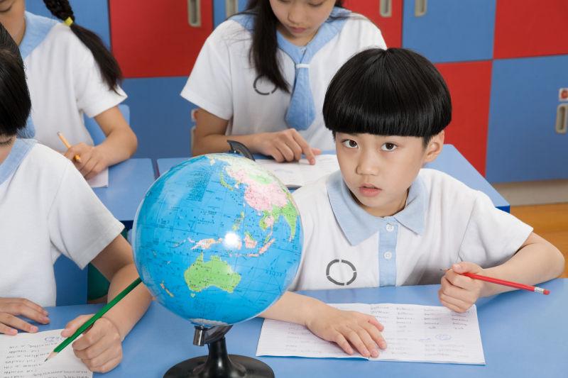 在教室的课桌前写字的学生