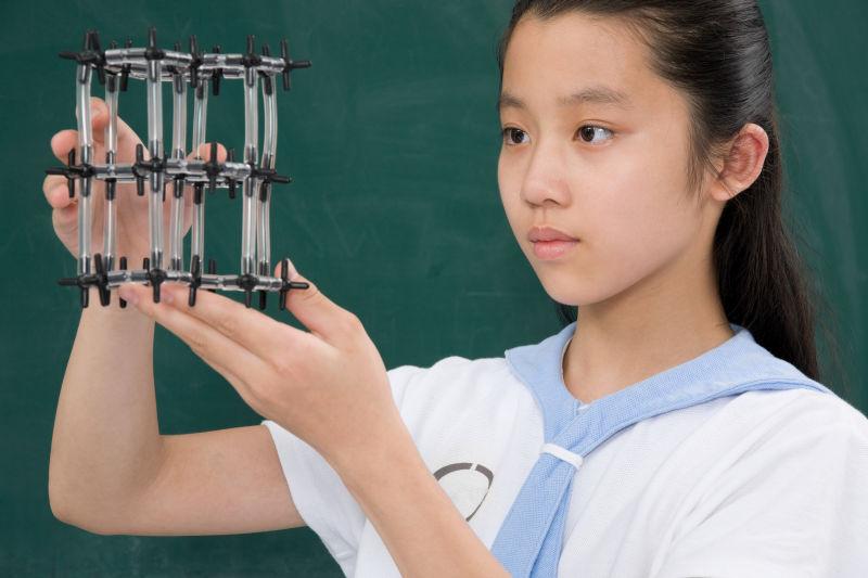 在教室中观察科学模型的女学生
