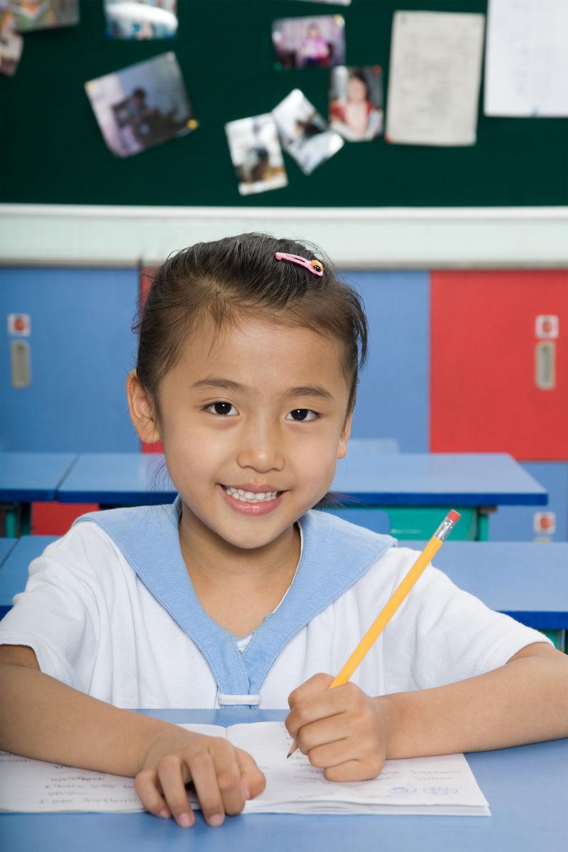 教室内写字的微笑的女学生