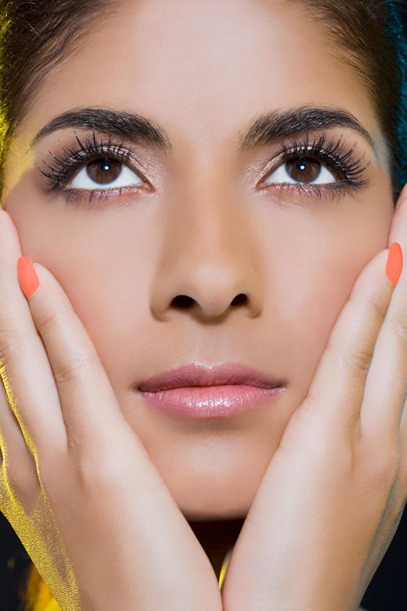 双手抚摸着脸颊的女人