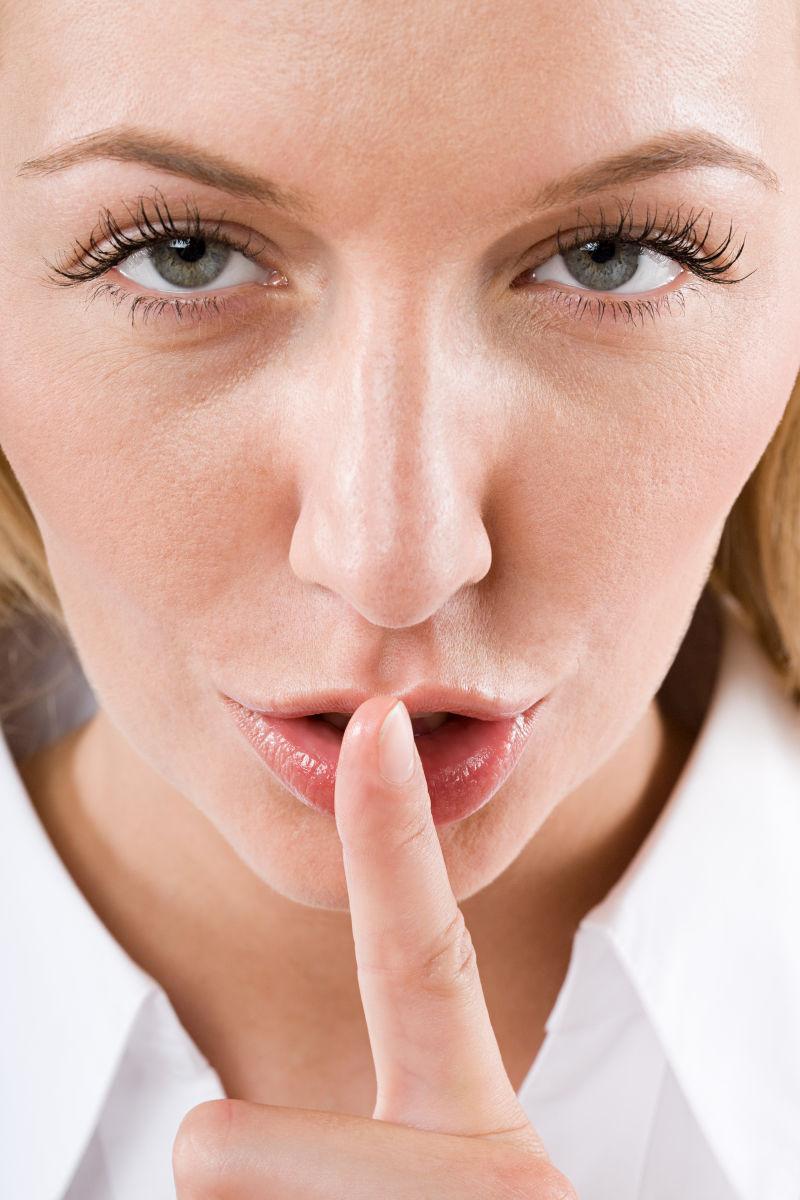 手放在嘴前禁声的美女