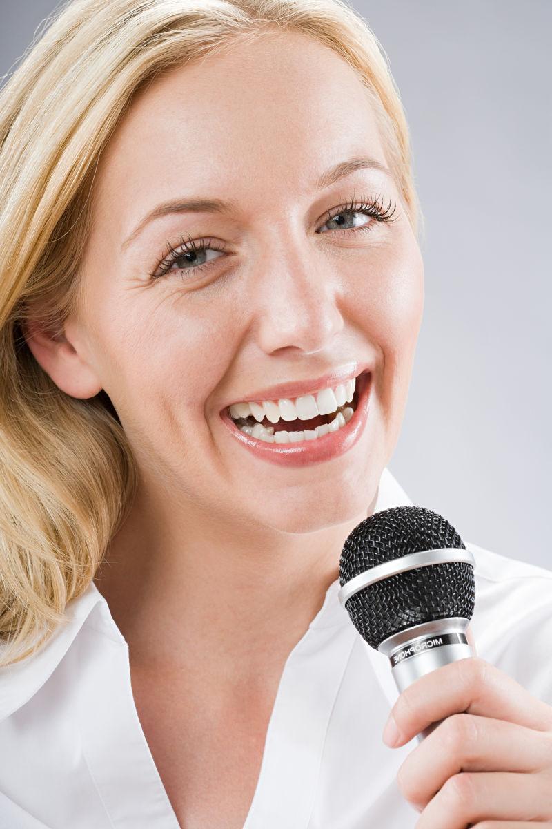 拿着麦克风微笑的金发美女