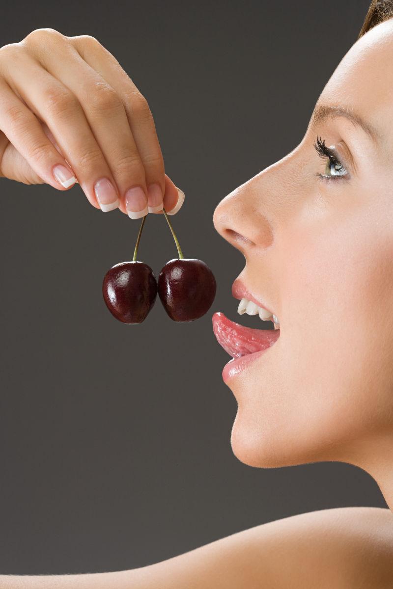 舔樱桃的年轻美女