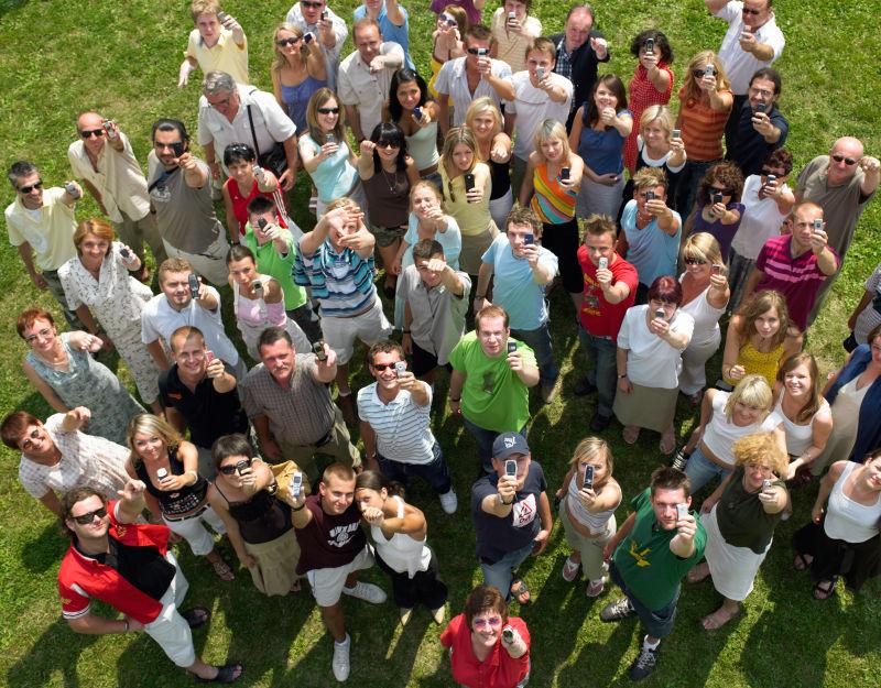 草地上拿着手机的人群