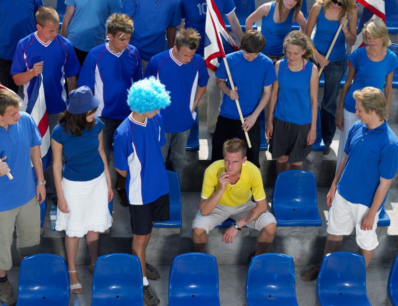 黄衣服的球迷被一群蓝衣服的球迷围堵着