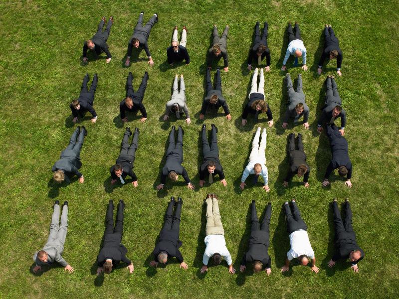 在草地上做着俯卧撑的商人