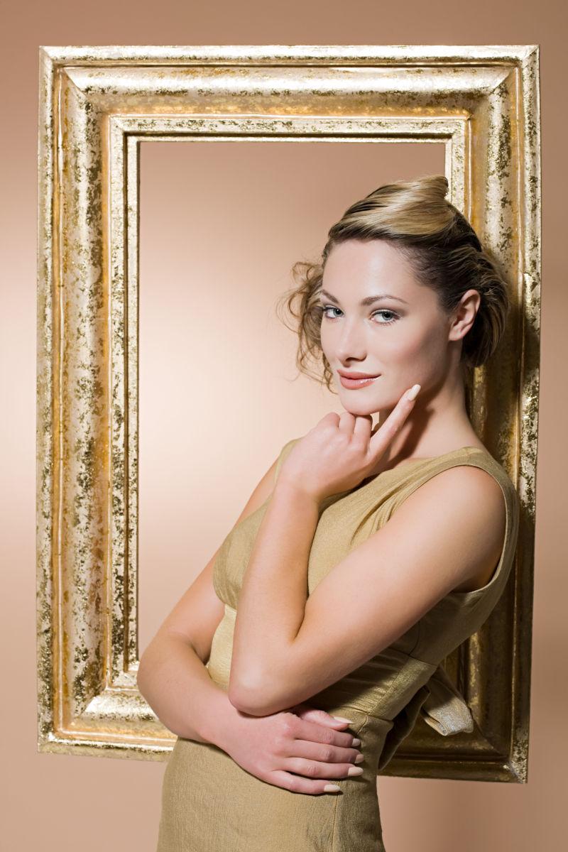 站在金色画框旁的女人