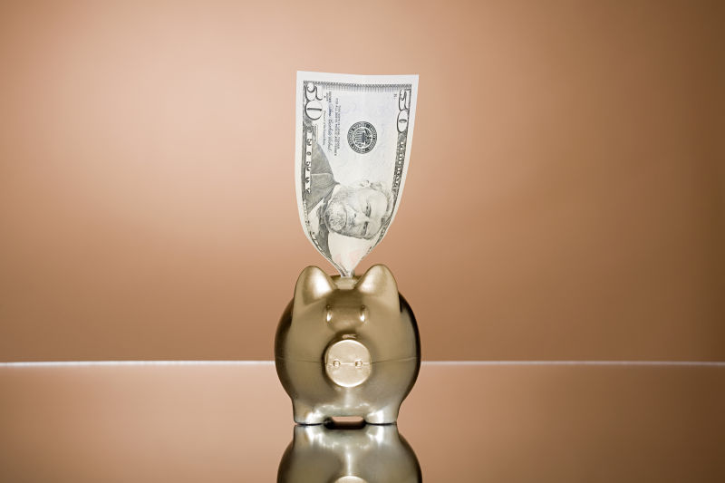 一张钞票插在玻璃储蓄罐上