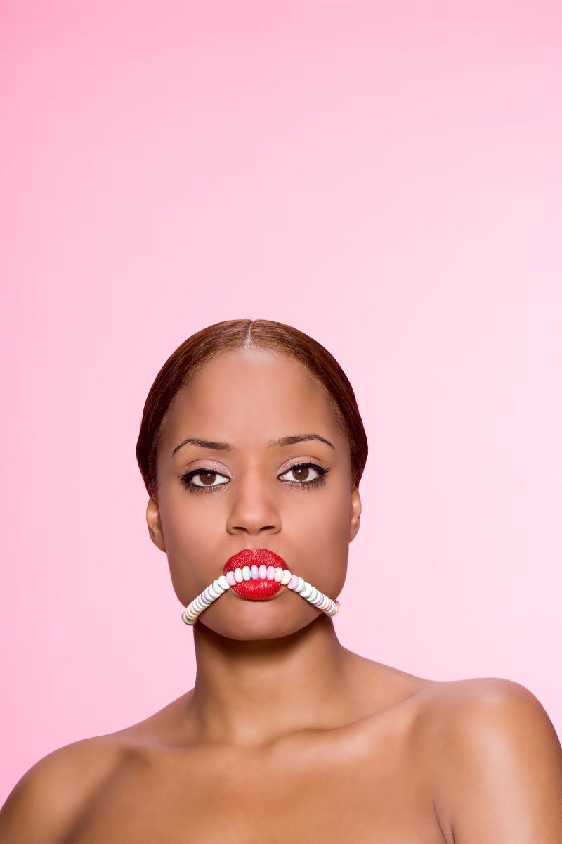 年轻美女咬糖果项链