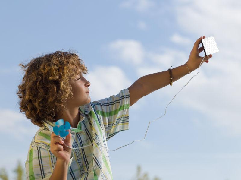 使用小型太阳能电池板的男孩