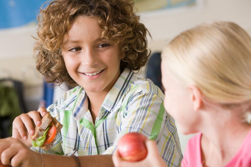 坐在教室内吃东西的孩子