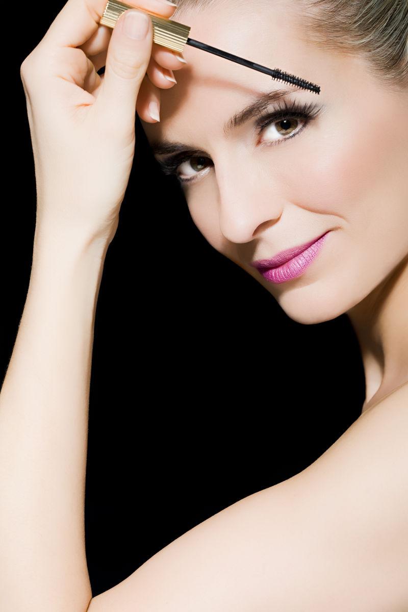 黑色背景下化妆的美女