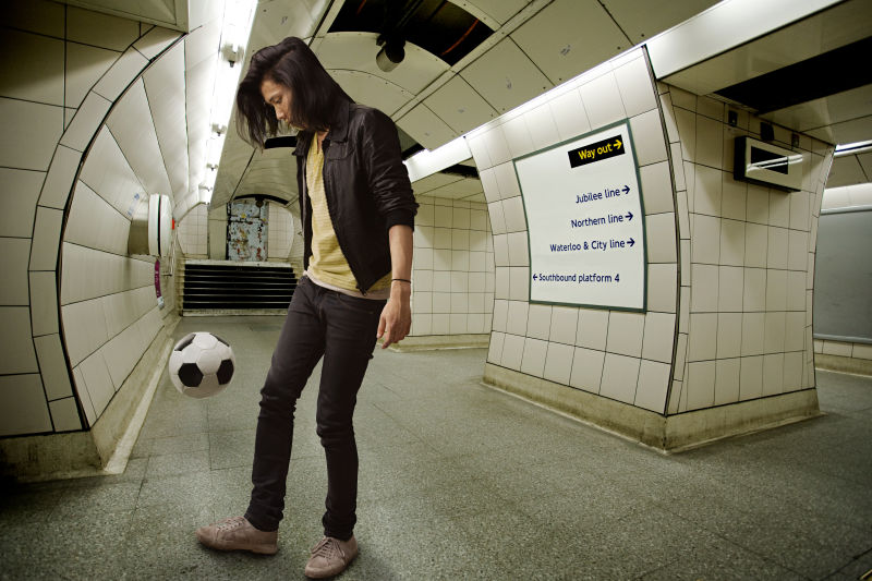 在地铁里踢足球的男人