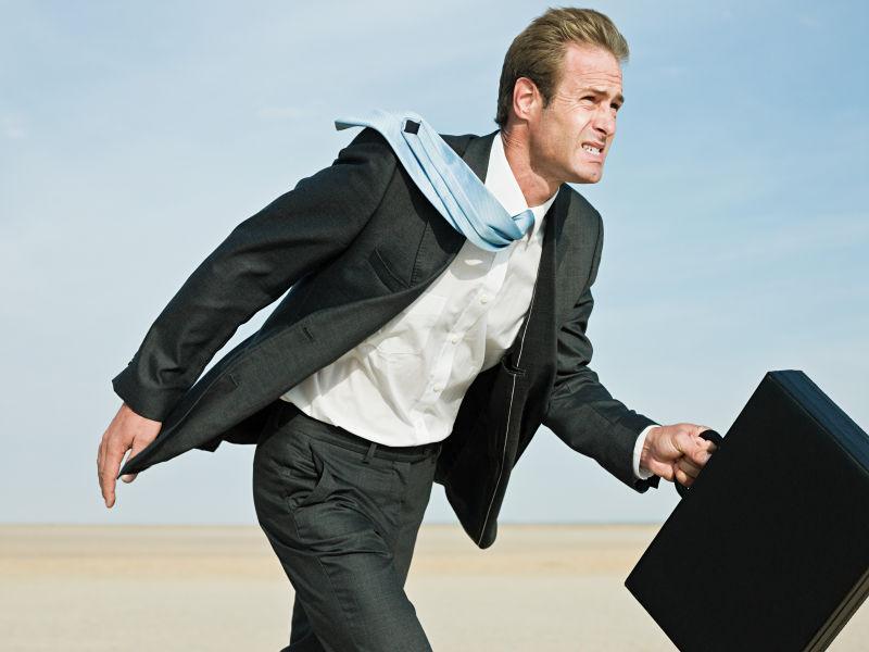 干旱土地上的商人在风沙中行走