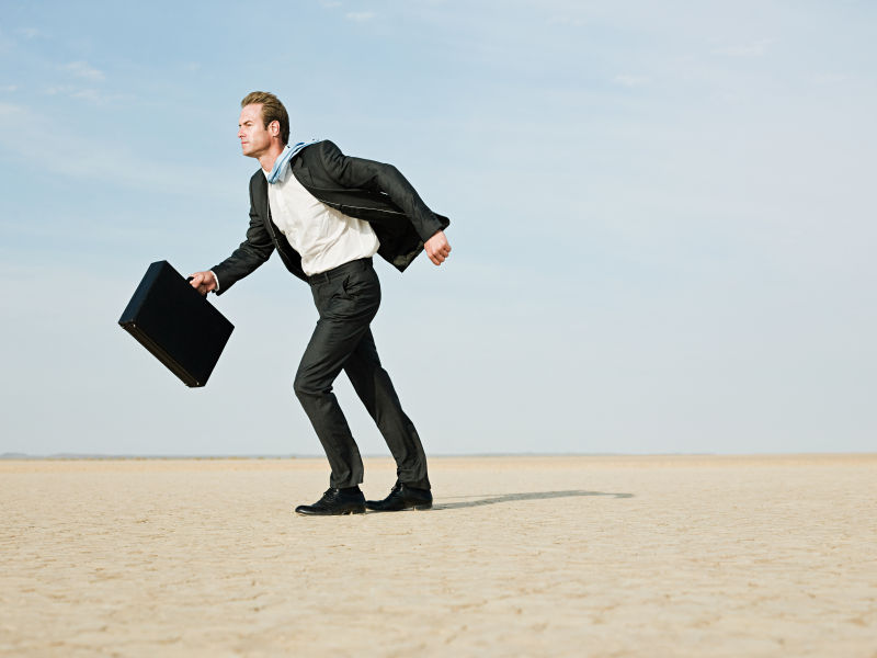 干旱土地上逆风而行的商人