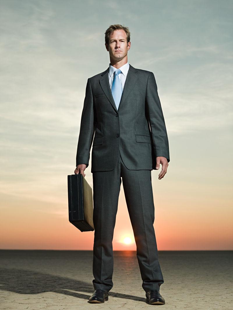 干旱土地上拿公文包的商人