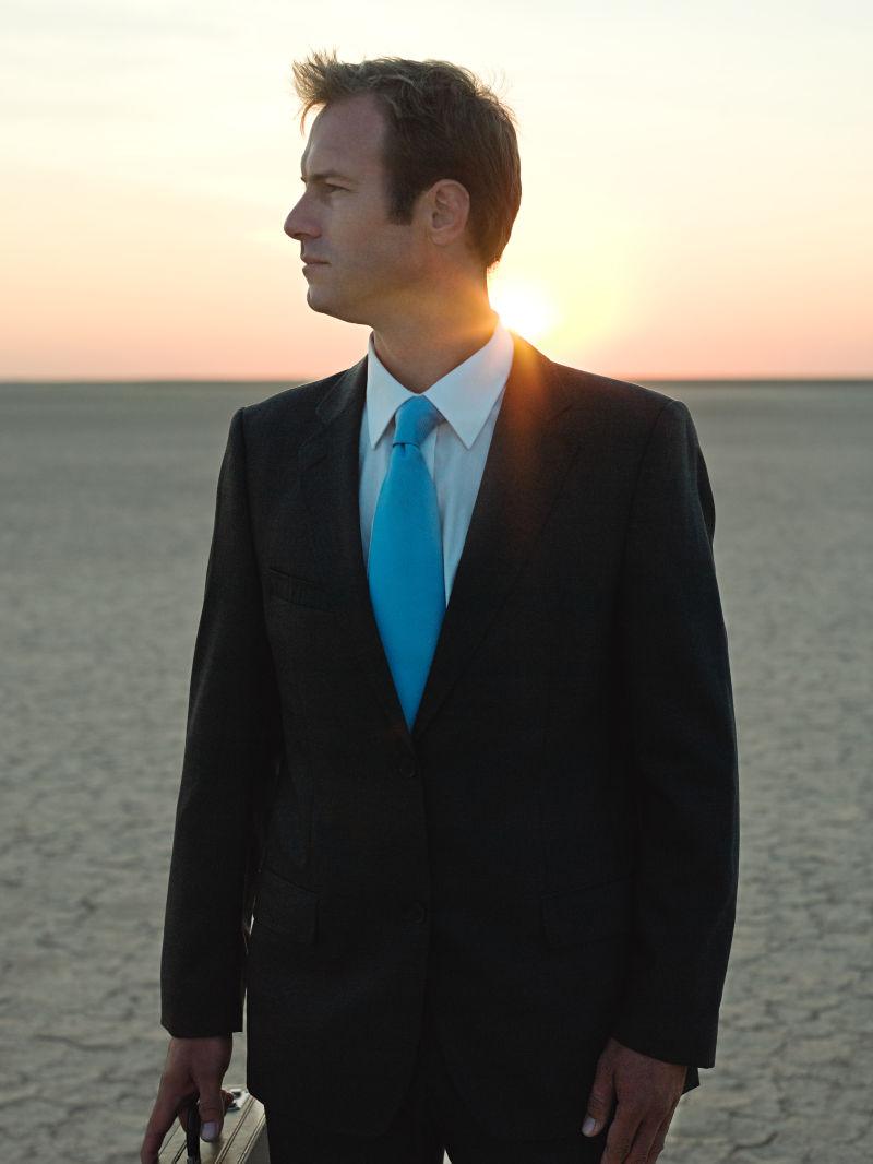 夕阳下干旱土地上的商人