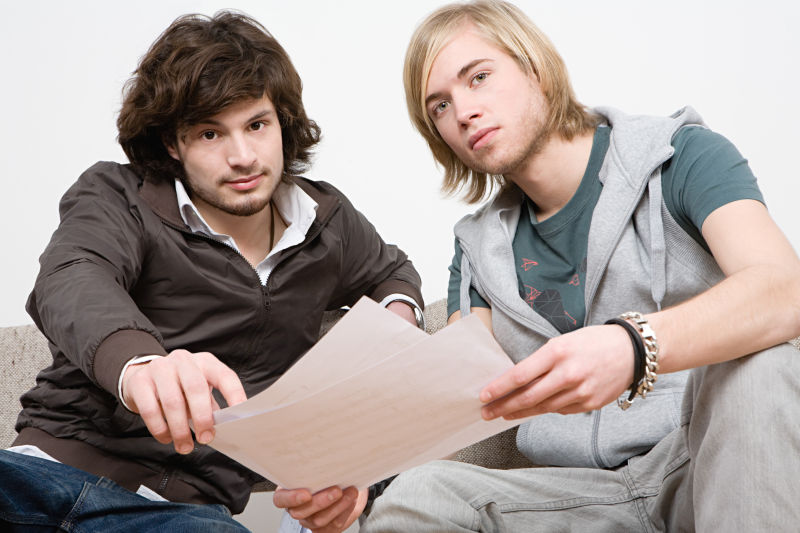 手拿乐谱的两个年轻男人